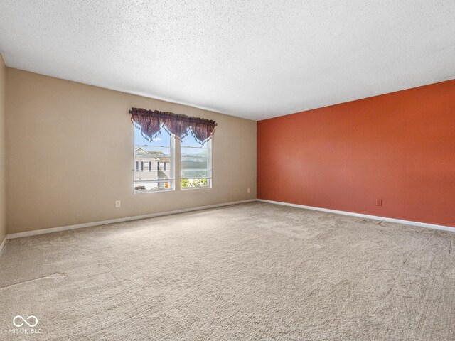 carpeted empty room featuring a textured ceiling