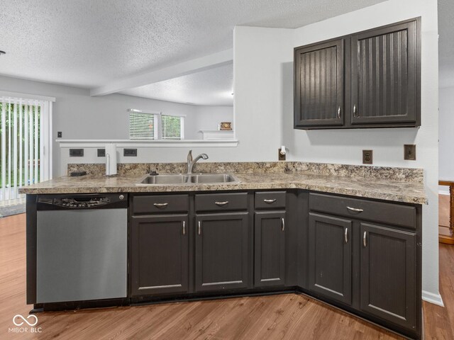 kitchen featuring dishwasher, sink, light hardwood / wood-style flooring, kitchen peninsula, and a textured ceiling