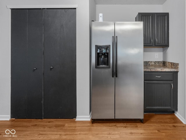 kitchen featuring stainless steel fridge, a textured ceiling, and light hardwood / wood-style flooring