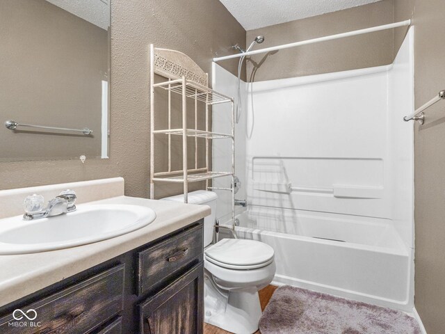 full bathroom with vanity, a textured ceiling, toilet, and shower / bathtub combination