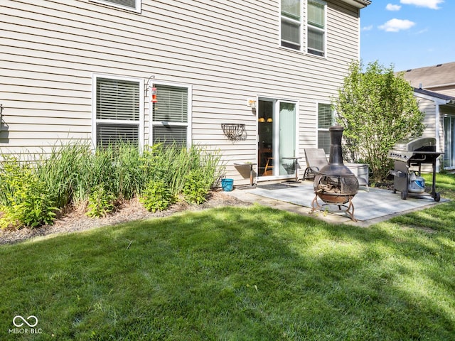 back of house featuring a yard, a patio, and an outdoor fire pit