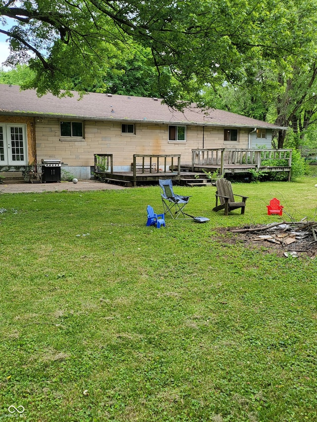 back of property featuring a deck and a yard