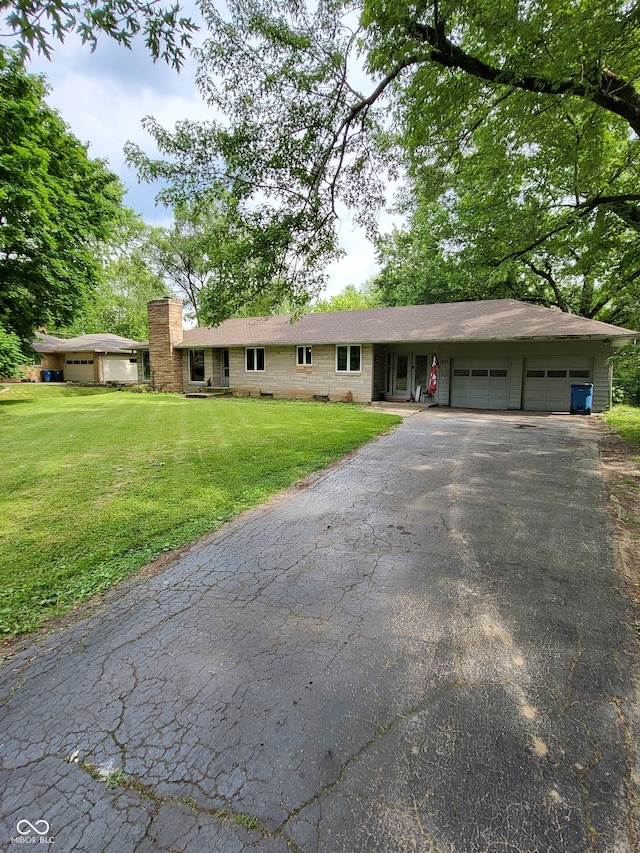 ranch-style house featuring a front lawn and a garage