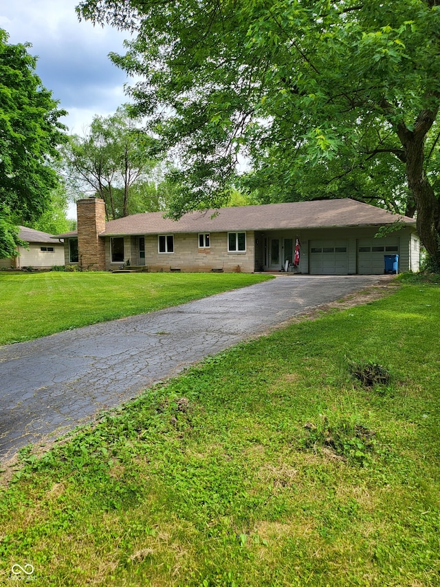 ranch-style house featuring a garage and a front lawn