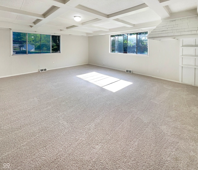 empty room featuring carpet flooring, beam ceiling, and coffered ceiling