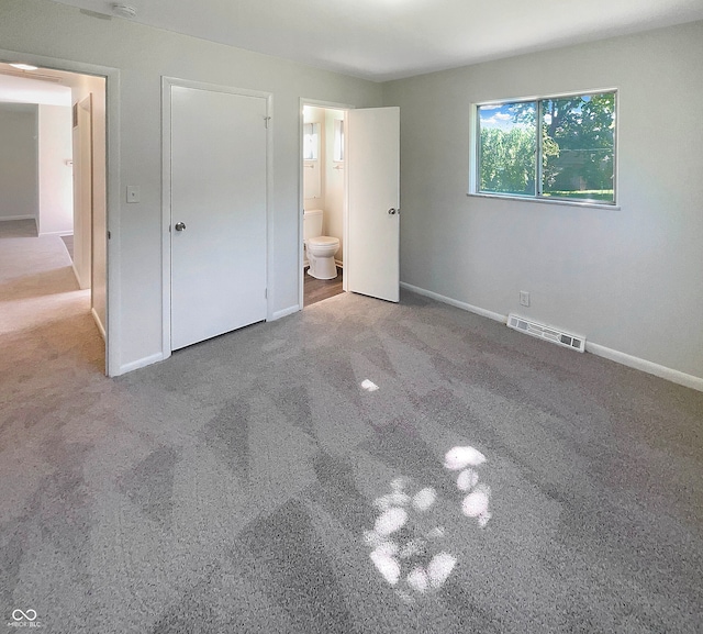 unfurnished bedroom with carpet flooring and connected bathroom