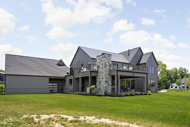 rear view of property featuring a balcony and a lawn