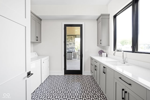 laundry room with cabinets, washing machine and dryer, and sink