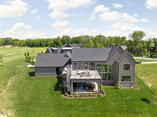 back of property with a lawn, a patio area, an outdoor hangout area, and a wooden deck