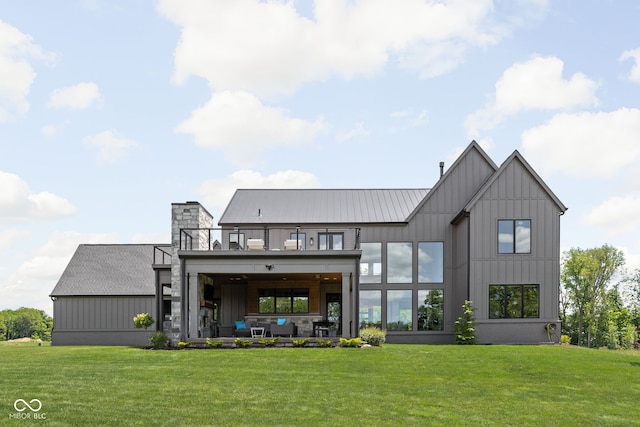 rear view of property with a lawn and a balcony