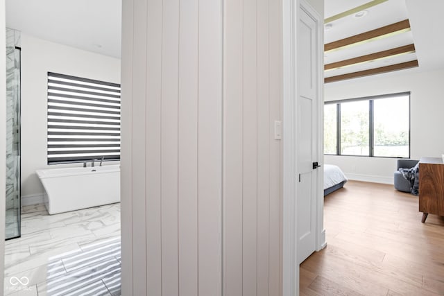 bedroom with beam ceiling and light hardwood / wood-style floors