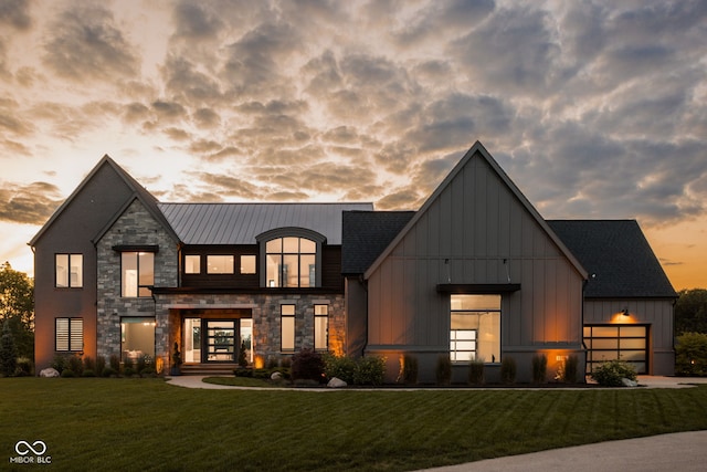 modern inspired farmhouse with a lawn, a garage, and french doors