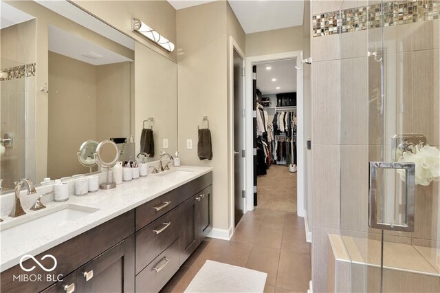 bathroom with tile floors, dual sinks, a shower with shower door, and oversized vanity