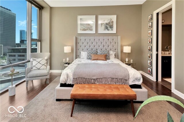 bedroom with dark hardwood / wood-style floors and a wall of windows