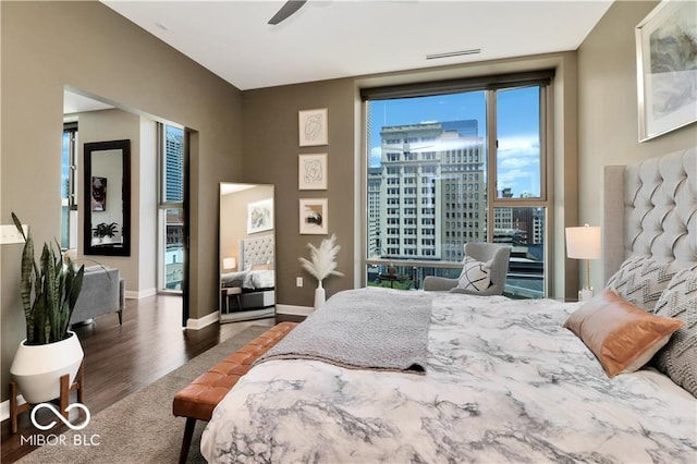 bedroom featuring floor to ceiling windows, dark wood-type flooring, and ceiling fan