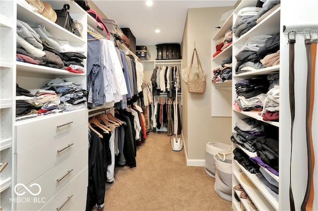 walk in closet featuring light colored carpet