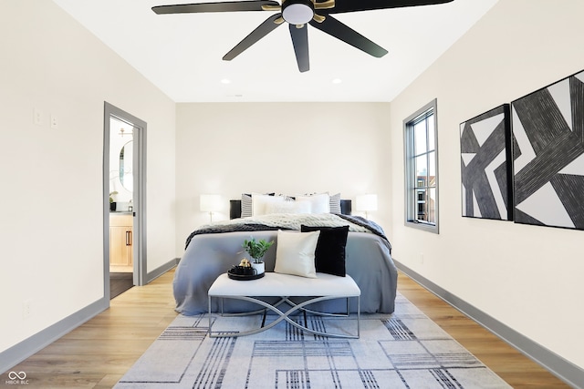 bedroom with light hardwood / wood-style floors, ceiling fan, and ensuite bathroom