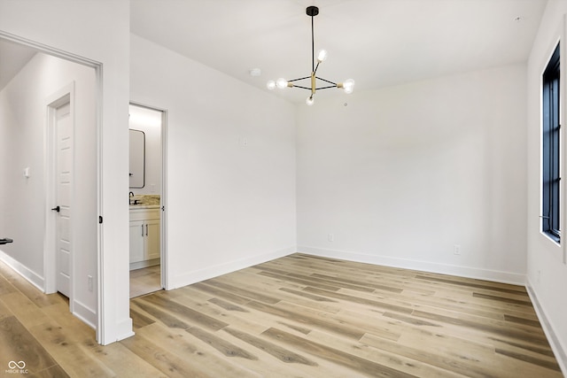 interior space with an inviting chandelier, sink, and light hardwood / wood-style flooring