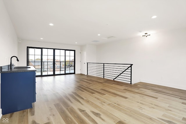 living room featuring light wood-type flooring and sink