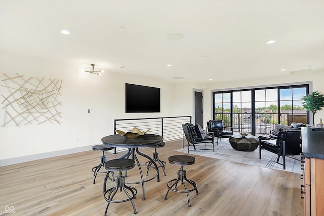 dining space featuring light hardwood / wood-style floors and an inviting chandelier