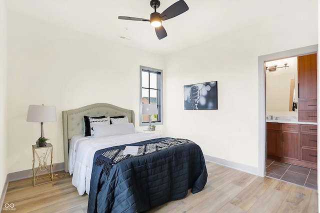 bedroom with connected bathroom, ceiling fan, and light wood-type flooring