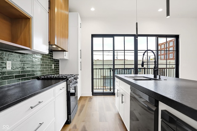 kitchen featuring white cabinets, sink, tasteful backsplash, light hardwood / wood-style floors, and stainless steel appliances