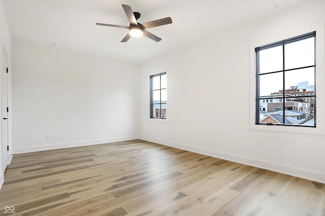 empty room featuring ceiling fan, light hardwood / wood-style flooring, and a healthy amount of sunlight