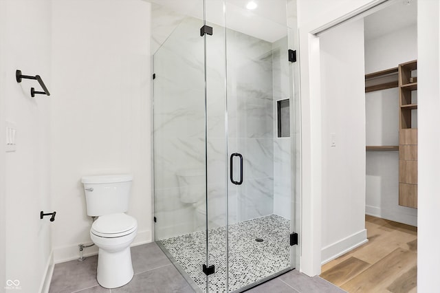 bathroom featuring wood-type flooring, toilet, and walk in shower