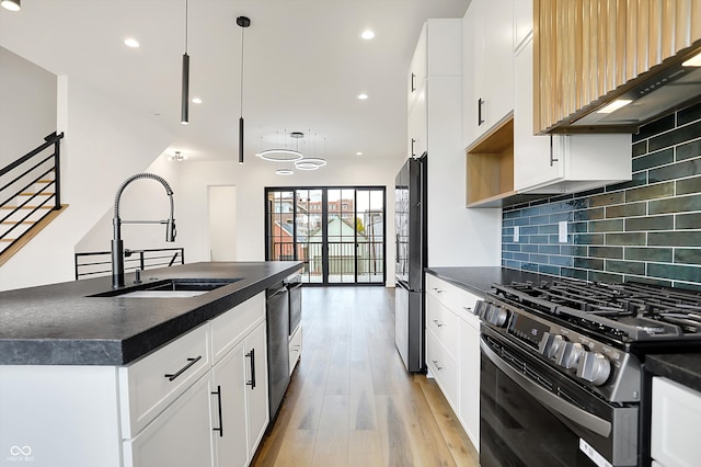 kitchen with white cabinetry, sink, decorative light fixtures, black appliances, and exhaust hood