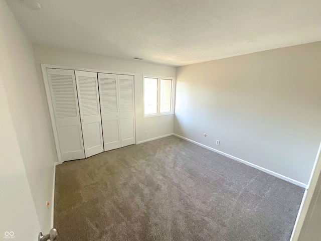 unfurnished bedroom featuring carpet floors and a closet