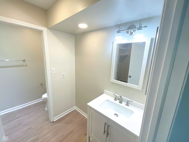 bathroom with vanity, hardwood / wood-style flooring, and toilet