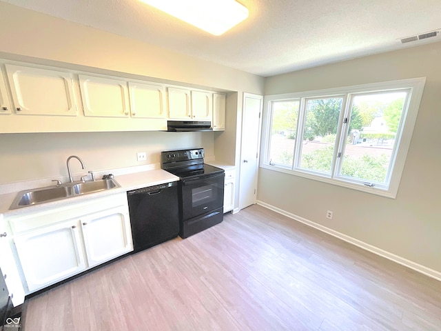 kitchen with sink, white cabinets, black appliances, and light hardwood / wood-style floors