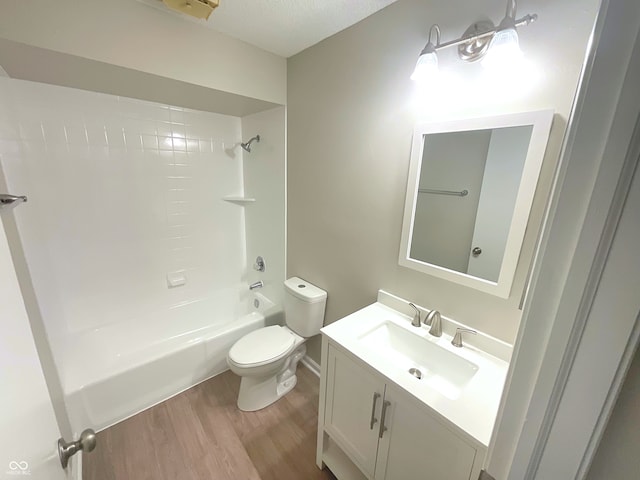 full bathroom with tub / shower combination, vanity, a textured ceiling, wood-type flooring, and toilet