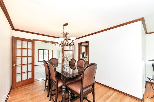 dining area featuring ornamental molding, french doors, a notable chandelier, and light hardwood / wood-style flooring