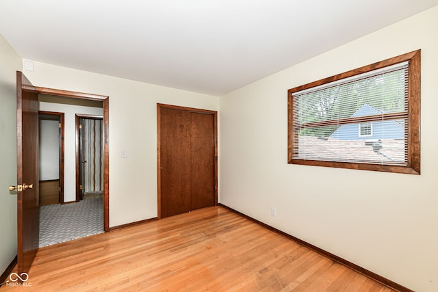 unfurnished bedroom with light hardwood / wood-style flooring and a closet