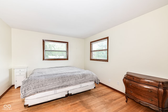 bedroom with light wood-type flooring and multiple windows