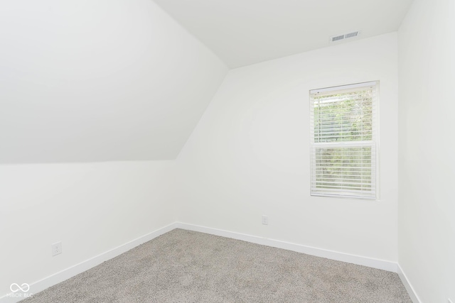 bonus room with lofted ceiling and carpet flooring