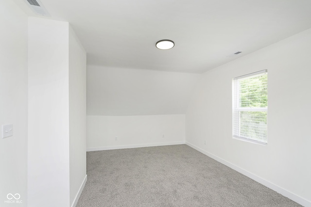 carpeted spare room featuring lofted ceiling