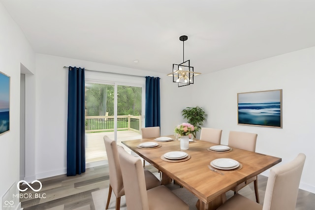 dining space featuring light hardwood / wood-style flooring and an inviting chandelier