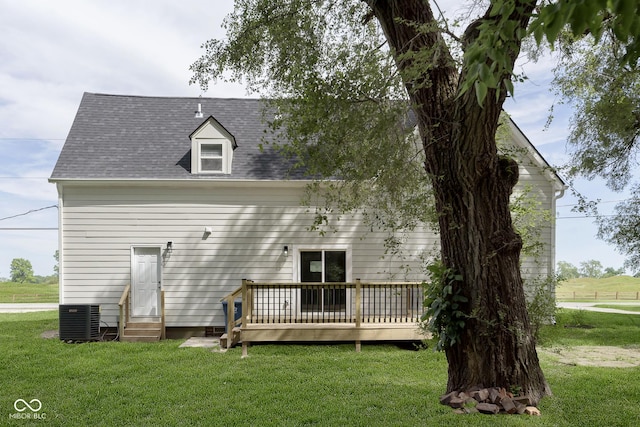 back of property featuring a wooden deck, cooling unit, and a lawn