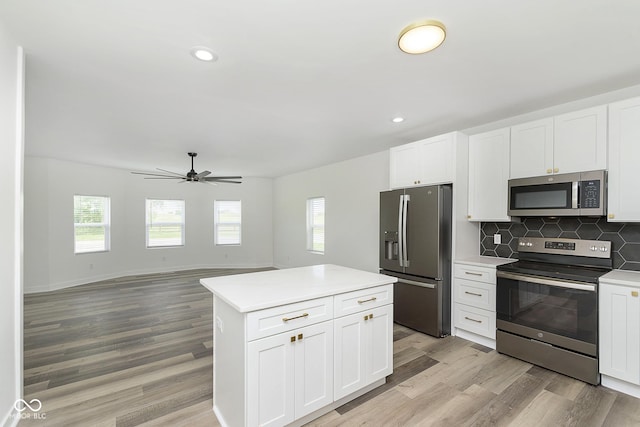 kitchen featuring appliances with stainless steel finishes, white cabinets, and tasteful backsplash