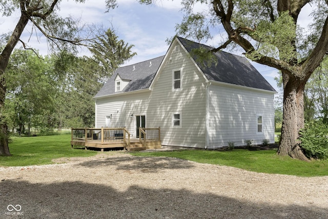 rear view of house featuring a deck and a lawn