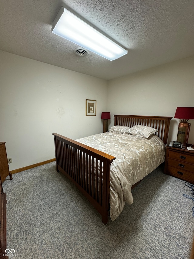 bedroom featuring a textured ceiling and dark colored carpet