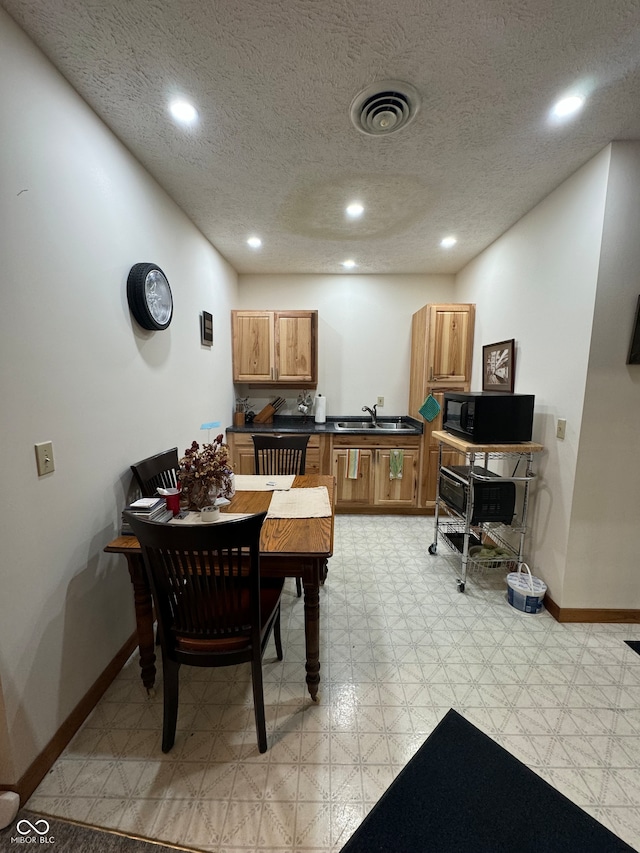 dining area featuring sink and a textured ceiling