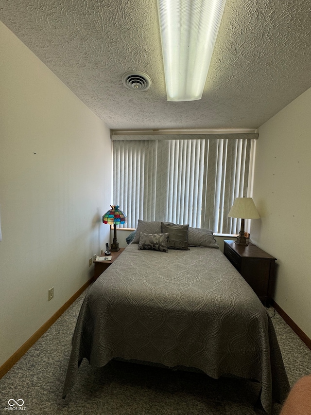 bedroom featuring carpet flooring and a textured ceiling