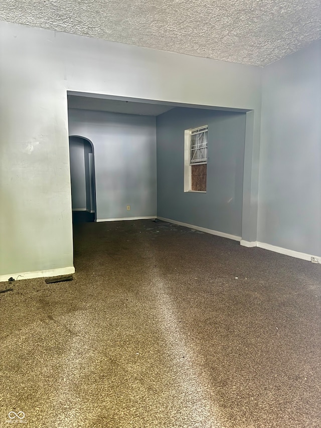 carpeted spare room featuring a textured ceiling