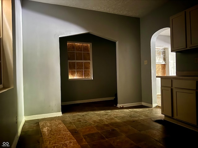 interior space featuring a textured ceiling and dark tile patterned floors