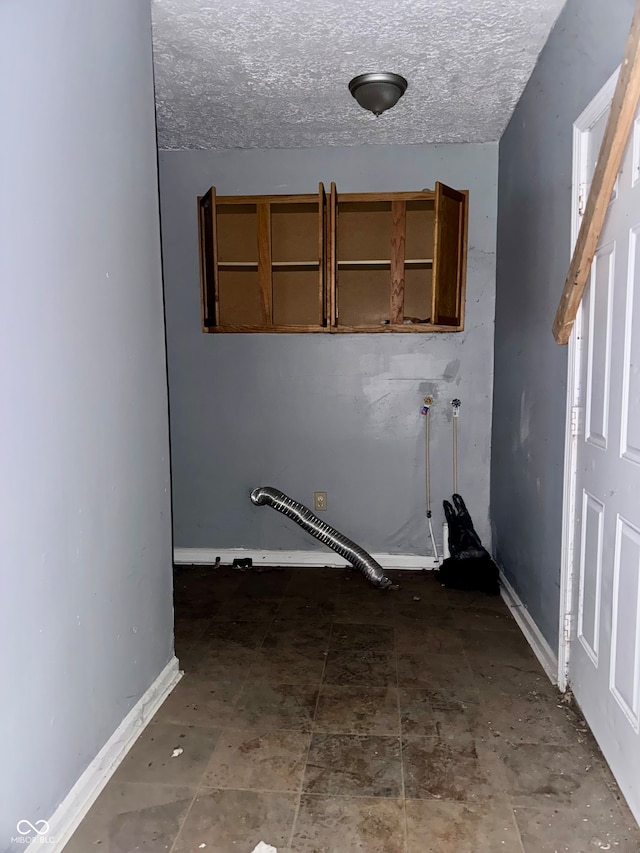 washroom with tile patterned floors and a textured ceiling