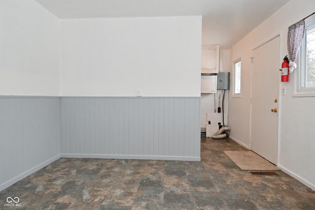 interior space with electric panel and wainscoting