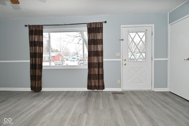 entrance foyer with ceiling fan, wood finished floors, visible vents, and baseboards